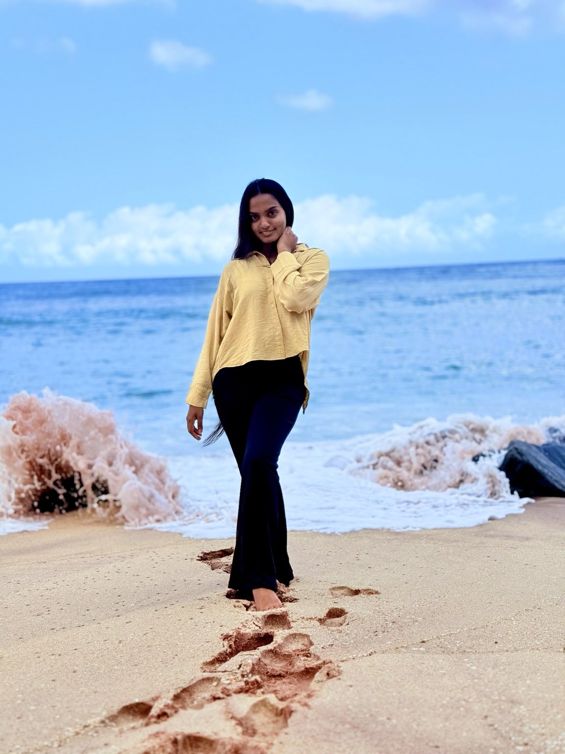 Muthu by the sea under a bright blue sky